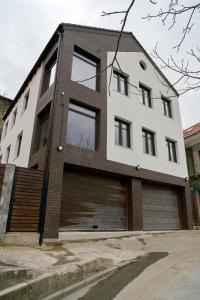 a white and brown building with a garage at Casa Piti in Braşov