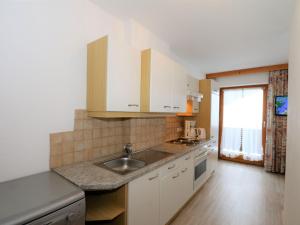 a kitchen with white cabinets and a sink at Apartment in Ischgl overlooking the mountains in Ischgl