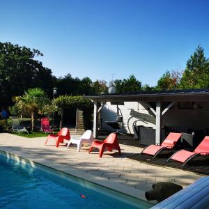 a group of red chairs and a swimming pool at Résidence Les Alizés ''JACCUZI SAUNA PISCINE en plein centre ville" in La Roche-sur-Yon