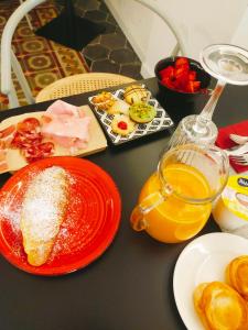 uma mesa com pratos de comida e um copo de sumo de laranja em Locanda Carra Manna em Sassari