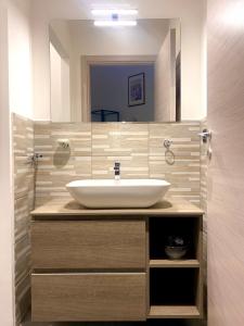 La salle de bains est pourvue d'un lavabo et d'un miroir. dans l'établissement B&B I miti dell Etna, à Catane
