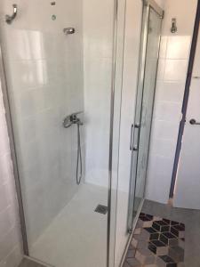 une douche dans une salle de bain avec une porte vitrée dans l'établissement Apartamento a 100m de la Cala Blanca, à Jávea