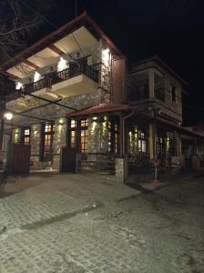 PanayítsaにあるGuesthouse Naoumaの大きな建物で、夜はバルコニーを利用できます。