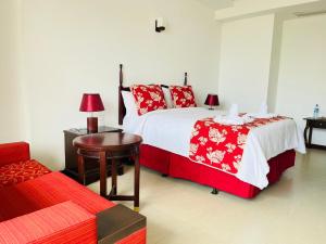 a bedroom with two beds and a table and a bed sidx sidx sidx at Bayfront in Weligama