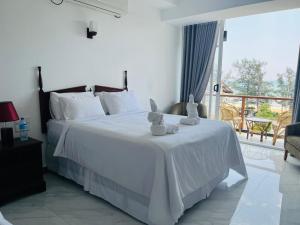 a bedroom with a white bed with two teddy bears on it at Bayfront in Weligama +127 photos