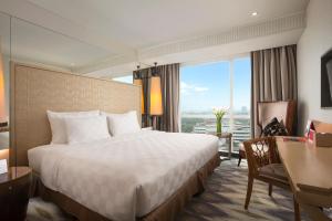 Habitación de hotel con cama, escritorio y ventana en Swiss-Belresidences Kalibata en Yakarta