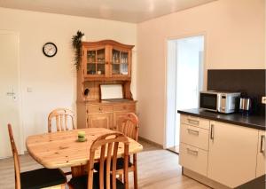eine Küche mit einem Holztisch und einer Mikrowelle in der Unterkunft Ferienwohnung Haus Sutter in Schopfheim