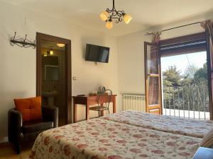 a bedroom with a bed and a chair and a window at Hotel Rural Poqueira II in Capileira