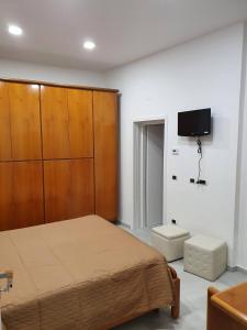 een slaapkamer met een bed en een tv aan de muur bij TIZY HOUSE - appartamento ammobiliato IMOLA in Imola