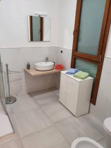 een witte badkamer met een wastafel en een spiegel bij TIZY HOUSE - appartamento ammobiliato IMOLA in Imola