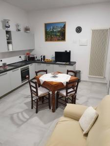 een keuken met een tafel en stoelen in een kamer bij TIZY HOUSE - appartamento ammobiliato IMOLA in Imola