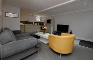sala de estar con sofá y silla en Harrogate Self Catering -Garden Mews, en Harrogate