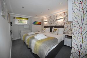 1 dormitorio con 2 camas y toallas. en Harrogate Self Catering -Garden Mews, en Harrogate