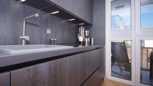 a kitchen with a large white sink and a window at Ferienwohnung Strandkrabbe in Baabe