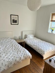 a bedroom with two beds and a table at Spacious 3 bedroom house close to city centre in Bristol