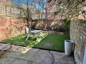 a picnic table in a courtyard with a brick wall at Spacious 3 bedroom house close to city centre in Bristol
