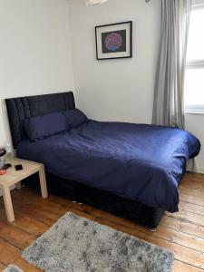 a bedroom with a bed and a table with a rug at Spacious 3 bedroom house close to city centre in Bristol