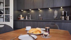 a table with two plates of bread and two cups of coffee at Ferienwohnung Strandkrabbe in Baabe