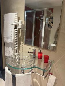 W łazience znajduje się szklana umywalka i lustro. w obiekcie Comfort Accommodation Loft w Bergamo