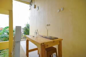 a wooden table in a room with a balcony at Pekayon Garden House Syariah RedPartner in Pekayon Dua