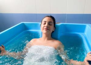 a woman is in a blue bath tub at Jermuk Ashkhar Sanatorium in Jermuk