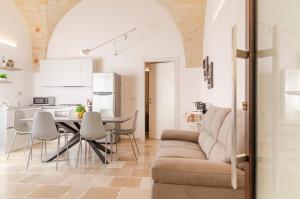 una cucina e un soggiorno con divano e tavolo di [ApuliaLux] Marietta Luxury House - Centro Storico a Brindisi