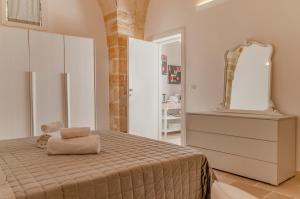 a white bedroom with a bed and a mirror at [ApuliaLux] Marietta Luxury House - Centro Storico in Brindisi