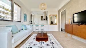 un soggiorno con un divano bianco e una TV a schermo piatto di LA LANTERNE a Nizza