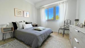 una camera da letto bianca con un letto e una finestra di LA LANTERNE a Nizza