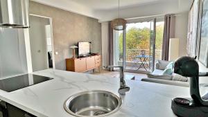 una cucina con lavello e un soggiorno di LA LANTERNE a Nizza