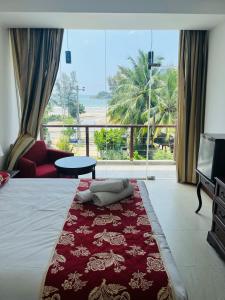 a hotel room with a bed and a large window at Bayfront in Weligama
