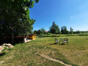 dos sillas y una mesa en un campo en Ferienwohnung Auszeit Objekt ID 13178-9 en Waren