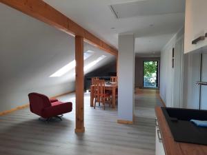 ein Wohnzimmer mit einem roten Stuhl und einem Tisch in der Unterkunft Ferienwohnung "Auszeit" Objekt-ID 131789 in Waren (Müritz)