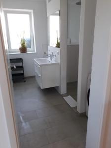 a white bathroom with a sink and a mirror at Appartments Eutiner Seepark in Eutin
