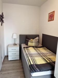 a small bedroom with a bed and a night stand at Apartement Meerblick in Wunstorf