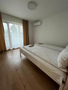 a bed in a room with a large window at Kati apartments in Varna City