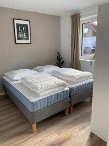 2 Einzelbetten in einem Schlafzimmer mit Fenster in der Unterkunft Appartments Eutiner Seepark in Eutin