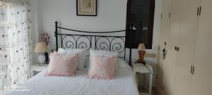 サン・ルイス・デ・サビニリャスにあるApartamento Turístico FlorHouseのベッドルーム(ピンクの枕が付いた黒と白のベッド付)