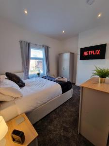 a bedroom with a large bed with a sign on the wall at 264 The Hungerford in Crewe