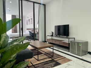 a living room with a tv and a couch and a table at Panorama Apartment in Da Lat