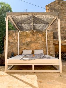 a bed with a canopy on a patio at Kleine Finca mit privatem Pool und Klima, ruhige Lage in Algaida