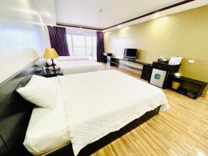 a hotel room with two beds and a television at Tuan Chau Havana Hotel in Ha Long