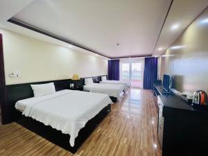 a hotel room with two beds and a television at Tuan Chau Havana Hotel in Ha Long