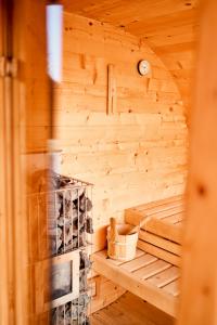eine Holzsauna mit einer Uhr an der Wand in der Unterkunft FARIE Mazury Dom na wyłączność dla 20 osób z Basenem, Sauną i Jacuzzi in Faryny