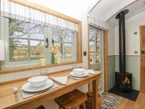 a dining room with a table with a wood stove at Acorn in Weston-super-Mare