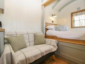 a small bedroom with a bed and a couch at Acorn in Weston-super-Mare