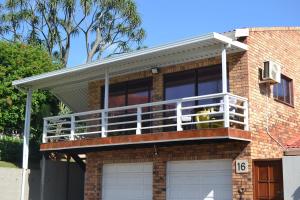 a dog sitting on a balcony on a house at Palmtree place - Stylish self catering unit in Umkomaas