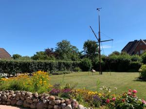 einen Garten mit Blumen und einem Feld im Hintergrund in der Unterkunft Haus Daheim in Utersum