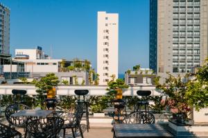 a patio with tables and chairs in a city at Dérive Boutique Villa & Apartment Da Nang in Da Nang
