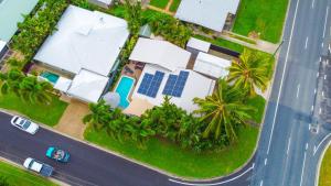 una vista aérea de una casa con un conjunto solar en Sweet Creek Cottage, Palm Cove, 200m to Beach, Heated Pool, Pets en Palm Cove